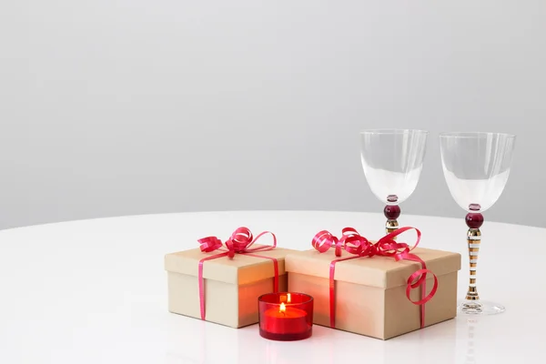 Geschenke, Weingläser und Kerzenschein — Stockfoto