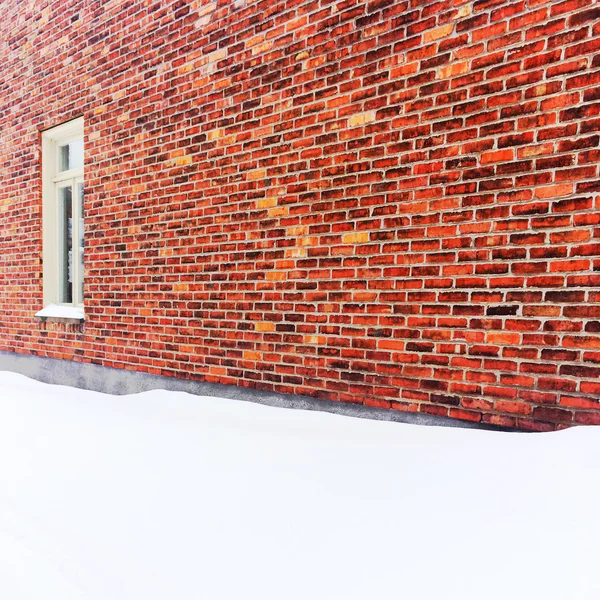 Spazio vuoto coperto di neve vicino a un muro di mattoni — Foto Stock