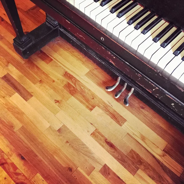 Piano vintage no chão de madeira velha — Fotografia de Stock