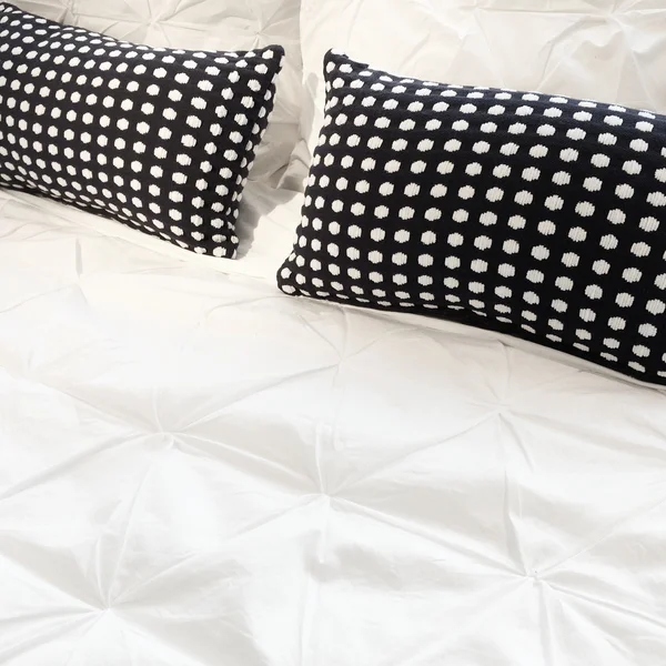 Weiße Bettwäsche mit schwarzen Kissen — Stockfoto