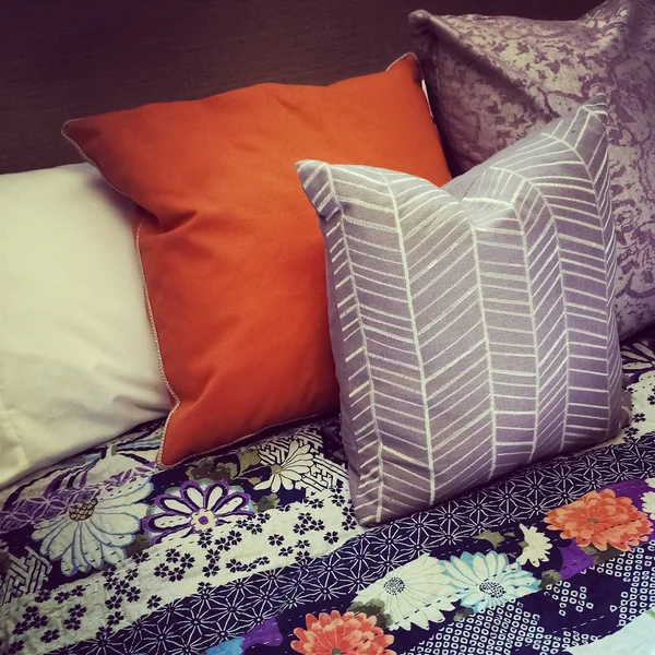 Almohadas de colores en una cama — Foto de Stock