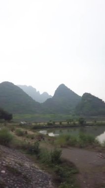 Song Sao Khe Nehri Ninh Binh, Trang An, Vietnam. Bulutlu bir günde arka planda dikey çekim kireç taşı karst.