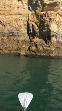 Benagil Mağarası Portekiz manzarasına kürek panosundan yaklaşıyoruz. Dikey görünüm görüntüsü veriliyor.