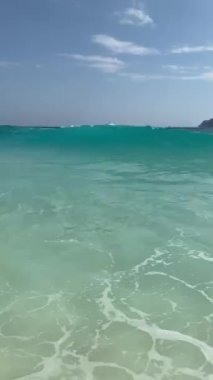 Kristal berraklığında plaj dalgası, Bali 'deki beyaz kumsala vururken kameraya doğru geliyor, Nusa Penida.