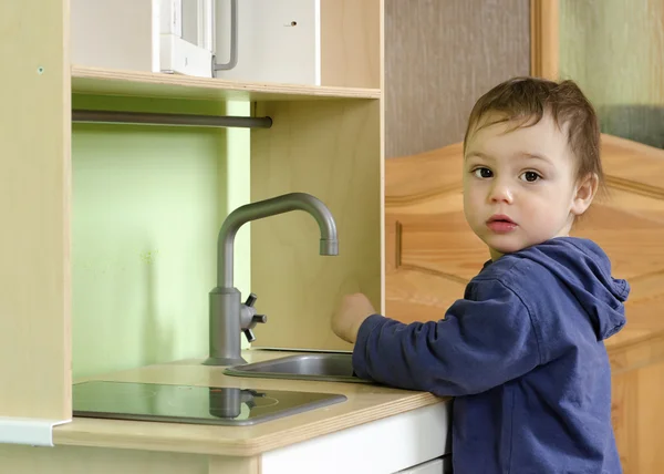Dítě hrající hračka kuchyni — Stock fotografie
