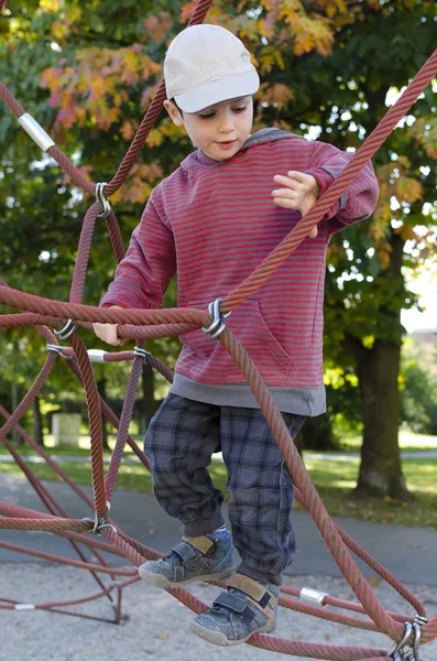 Criança escalando no parque infantil — Fotografia de Stock