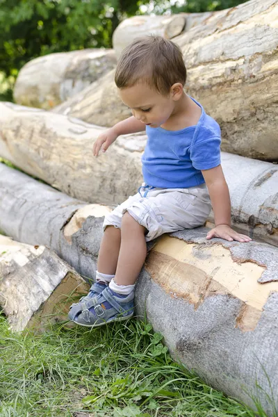 Kind op hout log — Stockfoto