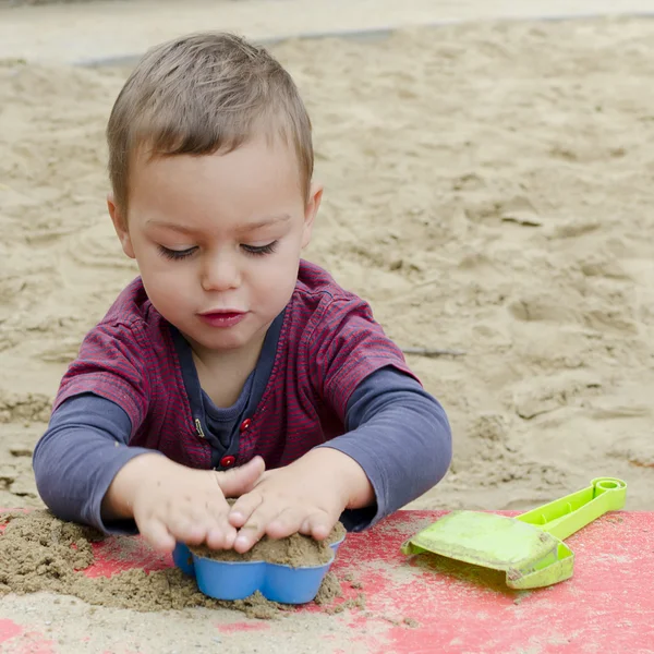 Sandpit içinde oynayan çocuk — Stok fotoğraf