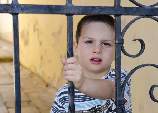 Niño detrás de una puerta o cerca —  Fotos de Stock