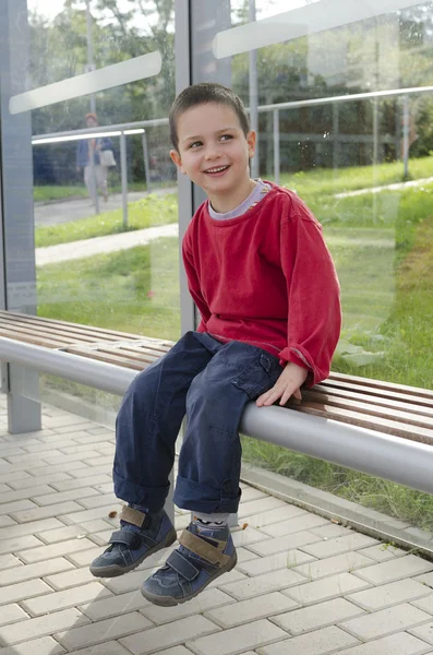 Niño en parada de autobús — Foto de Stock