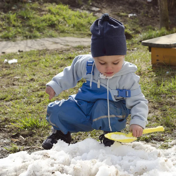 Niño jugando con nieve en primavera — Foto de Stock