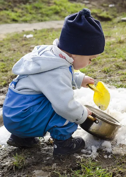 Весной ребенок играет со снегом — стоковое фото