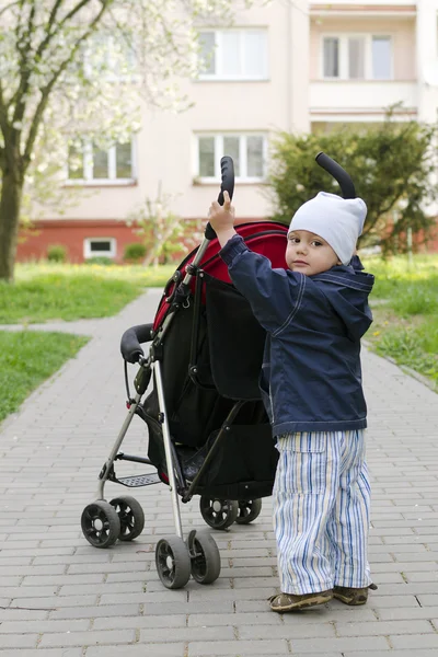 Child pushing stroller — Stock Photo, Image