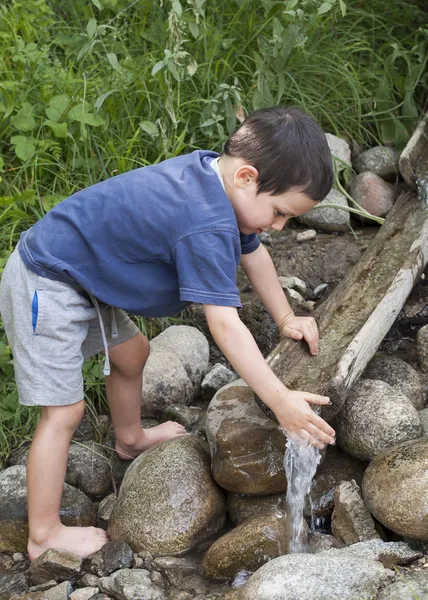 Niño en el arroyo de agua —  Fotos de Stock