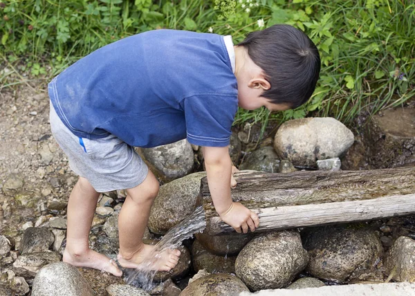 Niño en el arroyo de agua — Foto de Stock