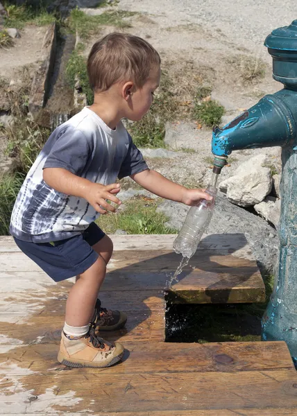 Kind füllt Wasserflasche — Stockfoto