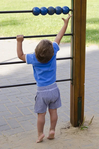 Niño jugando en el parque infantil — Foto de Stock
