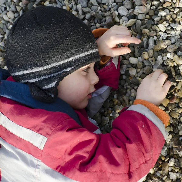 Enfant jouant avec des cailloux — Photo