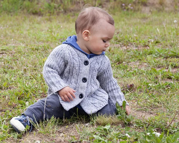 Çimlerde oturan çocuk — Stok fotoğraf