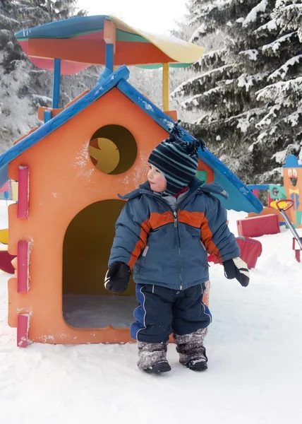 Bambino nel parco giochi invernale — Foto Stock