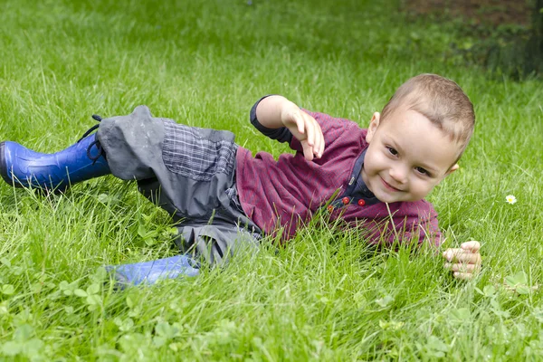 Enfant heureux jouant dans l'herbe — Photo