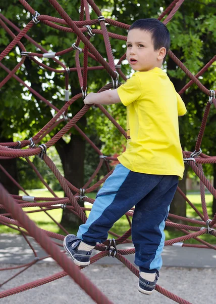 Criança escalando no parque infantil — Fotografia de Stock