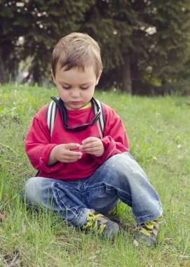 otların arasında oturan çocuk