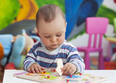 Toddler child playing with puzzle clipart