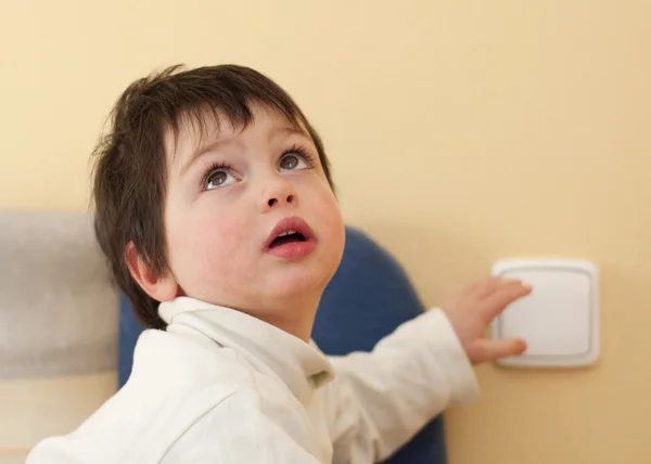 Niño y un interruptor de luz — Foto de Stock