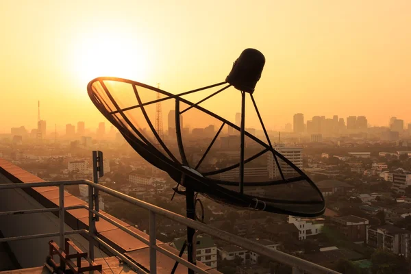 Parabolaantenna a tetőn, napkeltekor. — Stock Fotó