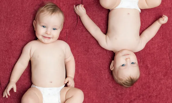 Zwei Babys auf rot — Stockfoto