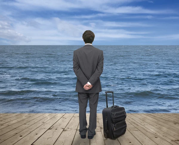 Businessman with a suitcase on pier — Stock Photo, Image
