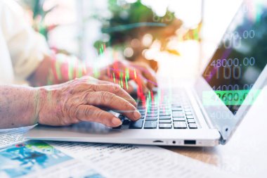 Close-up a senior retired old man using a laptop with hands pressing keyboard while sitting at home with market volatility chart. Trading stocks and crypto. Retirement investment concept. clipart