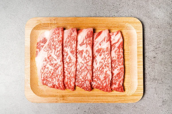 Ahşap bir tabakta yüksek mermer desenli bonfile Wagyu A5 bifteği. Yakiniku, Sukiyaki ve Shabu 'ya hizmet etmiş. Kopyalama alanı olan resim.