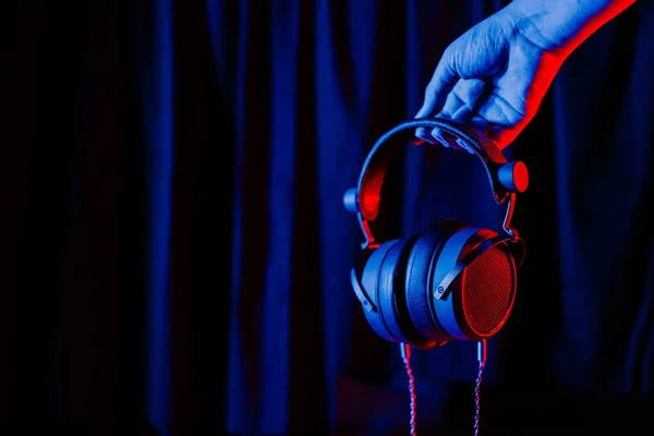 Рука Тримає Аудіофільні Навушники Прикрашені Синім Червоним Світлом Розмитому Чорному — стокове фото