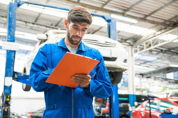 Mechaniker Blauer Arbeitskleidung Checken Die Checkliste Für Die Fahrzeugwartung Hintergrund — Stockfoto