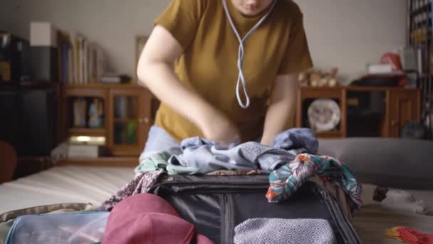 亚洲女人试图用挣扎把行李里的东西都装上 比如太阳镜 偏振镜 化妆品袋和小包 收拾东西去度假去了 慢动作视频 — 图库视频影像