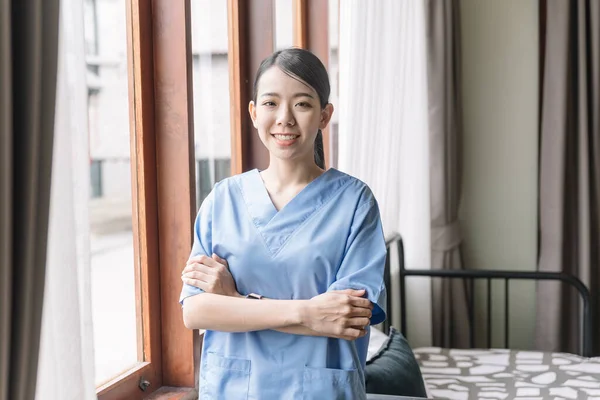 患者の家に医療用スクラブを着用したアジアの女性看護師の肖像画 介護者が家に来る ホームヘルスケアと介護ホームコンセプト — ストック写真