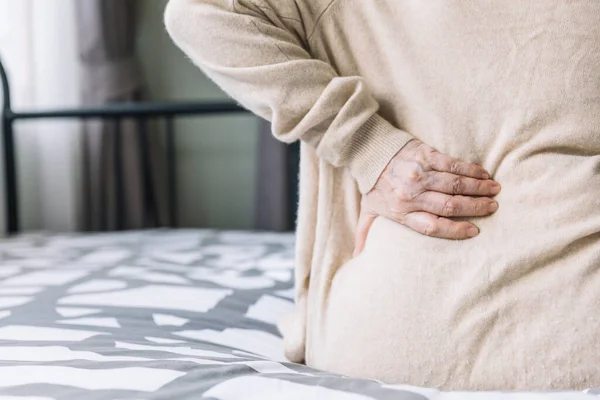 Yetişkin, son sınıf öğrencisi bir kadın yatakta acılarını bastıran bir kazak giyiyor. Bel ağrısından muzdarip kas ağrısı uyanıyor. Kronik ağrı.