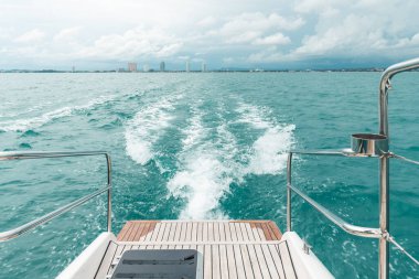 Arka planda Pattaya plajı ve gökyüzü olan katamaran yat motorundan deniz dalgası. Koh Larn, Chonburi, Tayland 'a doğru yola çıktı.