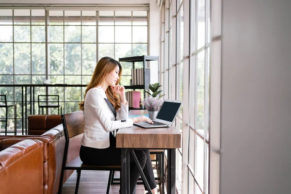 Ofis bölgesinde dizüstü bilgisayarda çalışan kendine güvenen profesyonel Asyalı iş kadını. Çevrimiçi iş liderliği ve girişimcilikte kadın rolü. Kopyalama alanı olan resim.