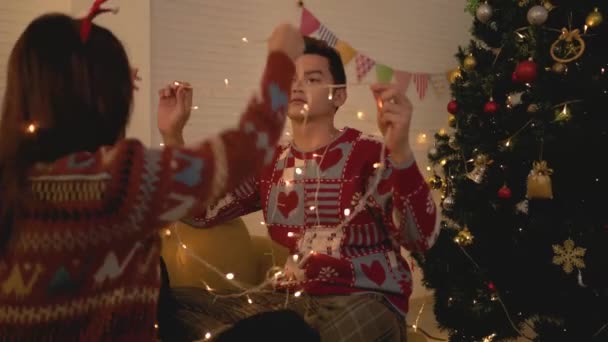 Asian Couple Wearing Sweaters Playing Tangled Led Lights Together Sofa — Stock Video