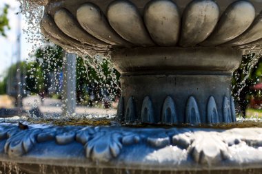 Arka planda güneşli bir gün sokağına damlayan damlalarla yakın plan fıskiyeli fıskiyeler