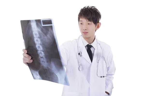 Radiologe untersucht Röntgenbild des Patienten mit der Hand auf dem Kopf — Stockfoto