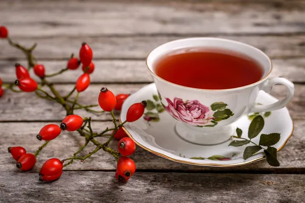 Tahta masada taze gül kalçalı bir fincan gül kalçası çayı.. 
