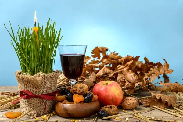 Noel kütüğü veya badnjak, elma, şarap, mısır gevreği, kurutulmuş meyve ve ahşap bir masada yanan bir mum. Ortodoks Noel kutlaması kavramı.