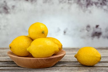 Eski ahşap bir masada bir grup taze limon..