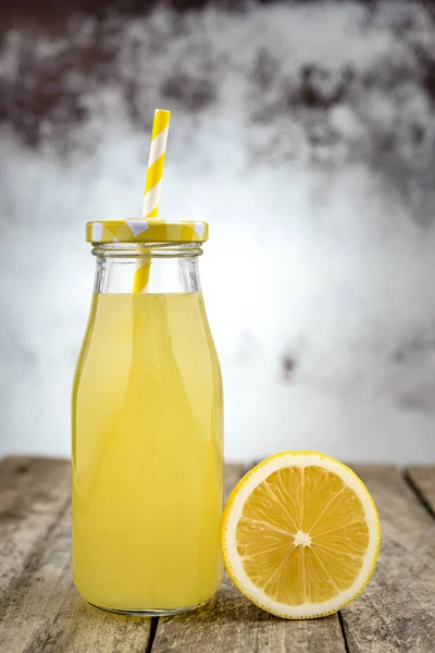Bir şişe saman ve limon dilimli soğuk limonata..