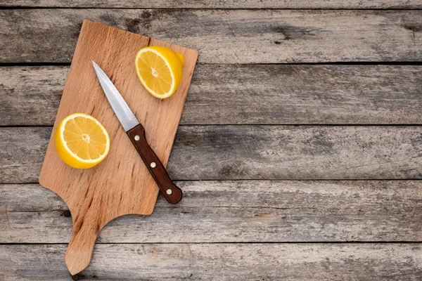 Taze limon ikiye bölünmüş ve tahta kesme tahtasının üzerinde yazı için fotokopi alanı olan bıçak. Üst görünüm.