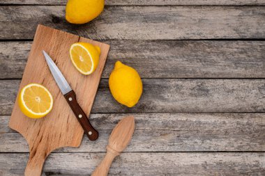 Tahta kesme tahtasındaki bıçakla kesilmiş taze limon. Üst görünüm.